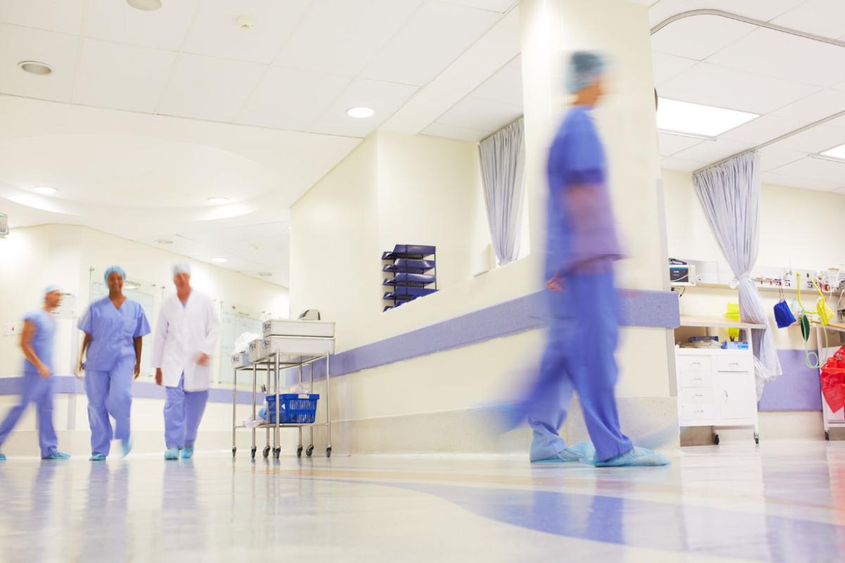 Several physicians walking through a hospital hallway
