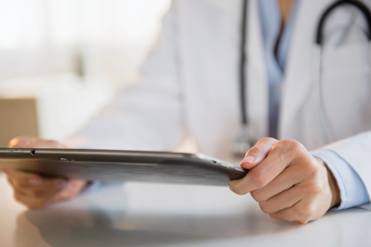 Close up of physician holding a tablet in his hands