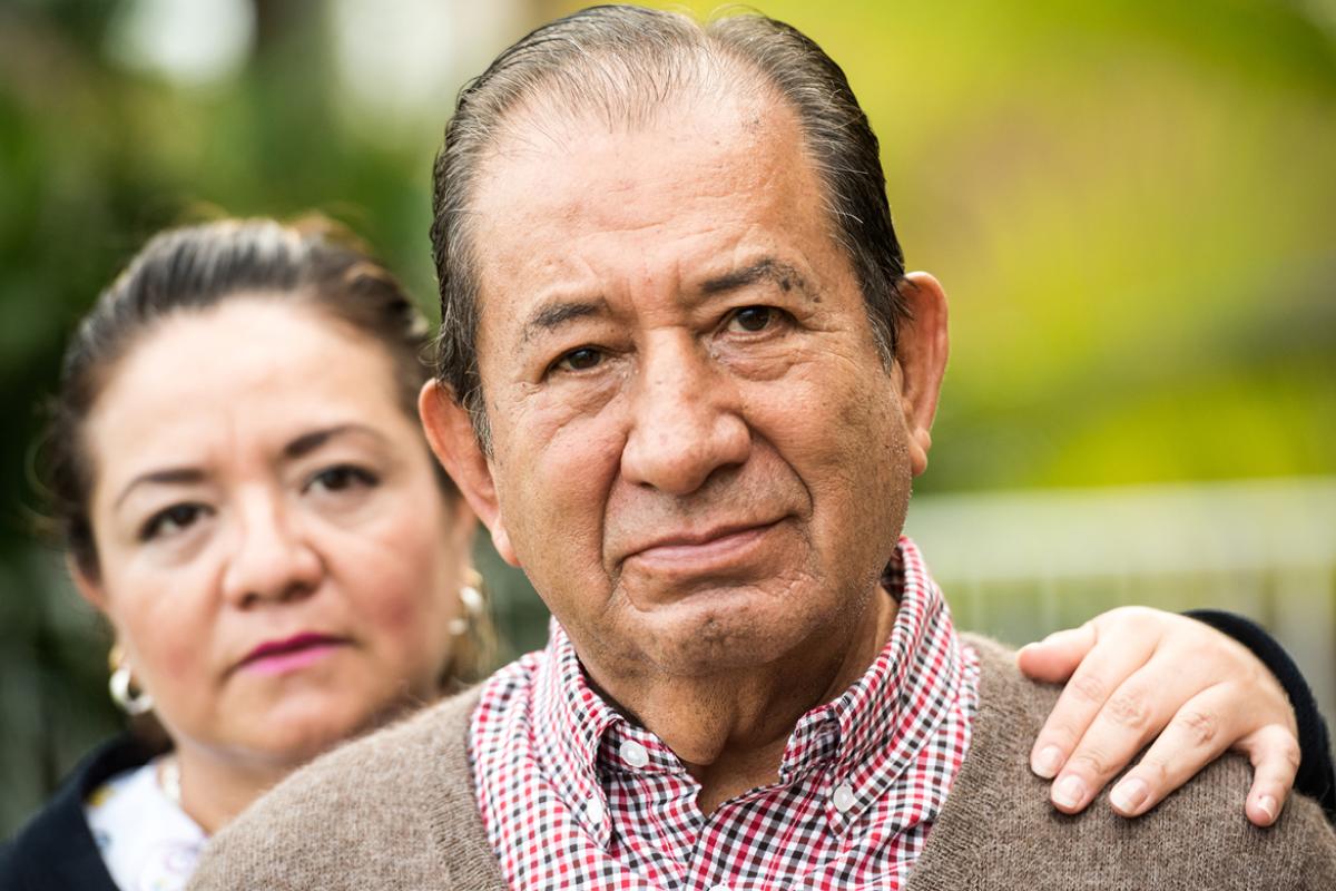 Elderly couple with one hand on the other's shoulder