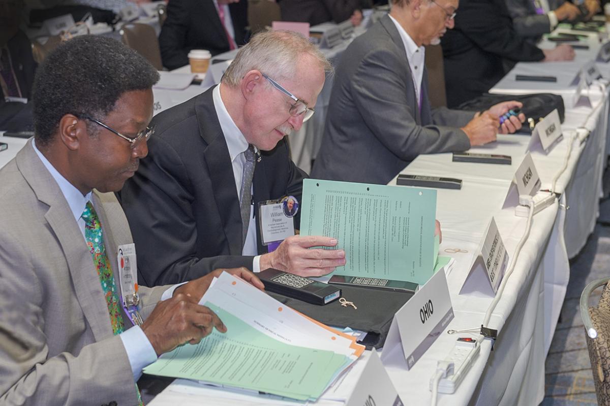Members reading reports at the Annual Meeting