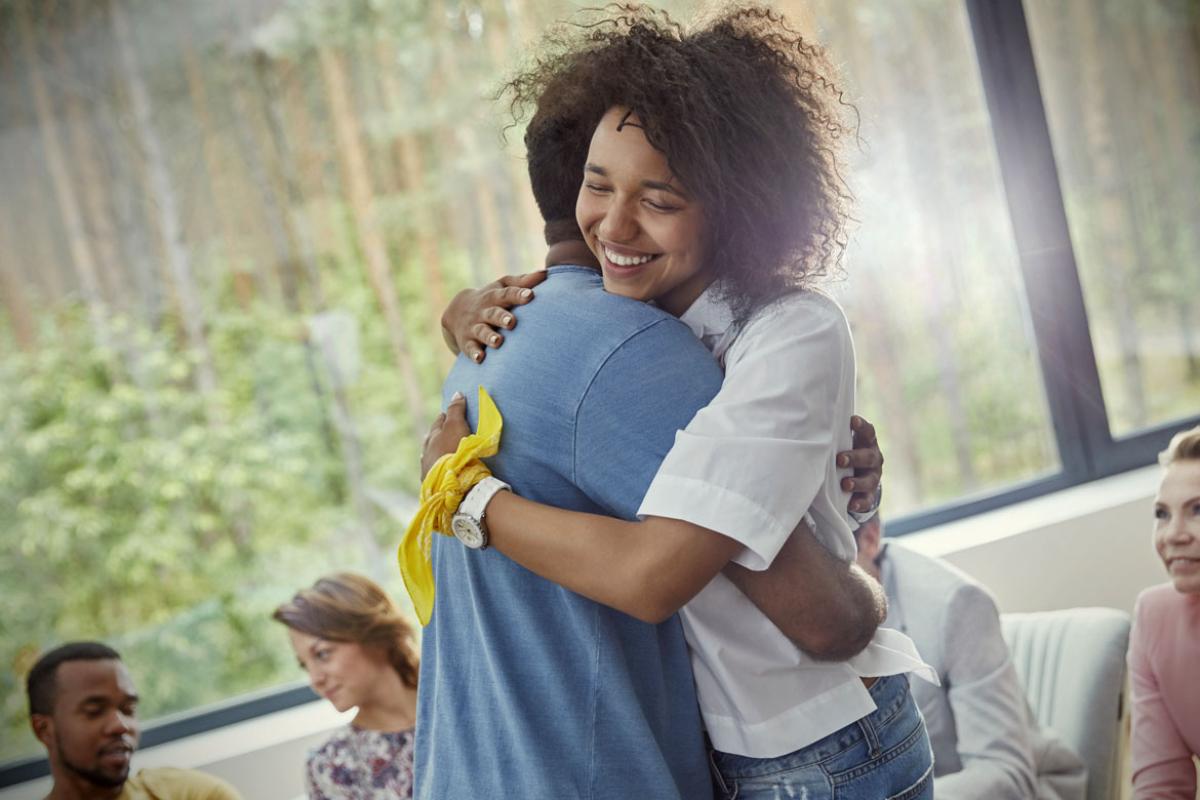 Two people hugging in a group setting