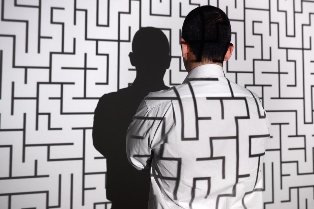 Projection of a maze on wall and man