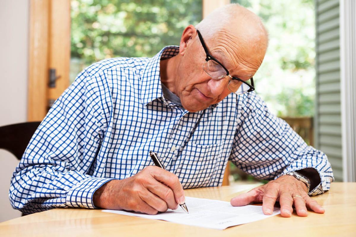 Elderly man writing