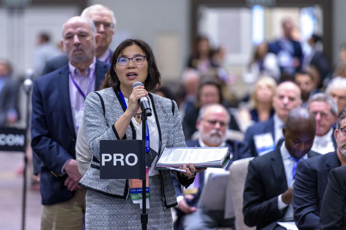 Female delegate speaking into microphone at the 2019 HOD Interim Meeting.