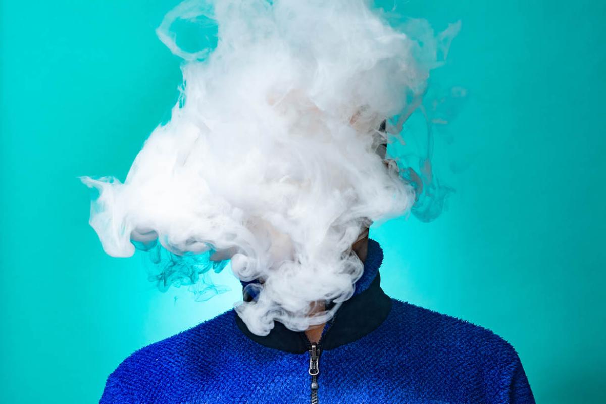 Person's face covered in cigarette smoke