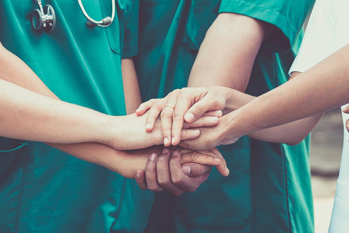 Group of physicians stacking hands