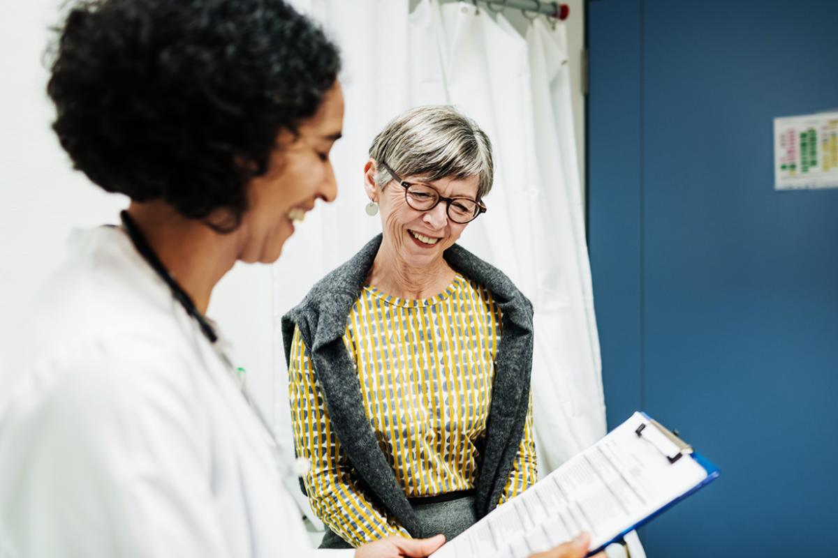 Smiling senior patient and physician reviewing patient chart