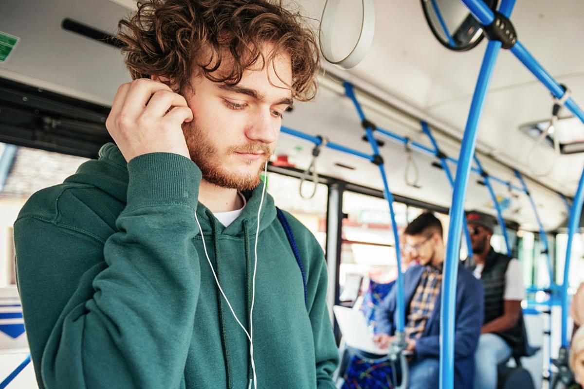 Young man with headphones on the bus