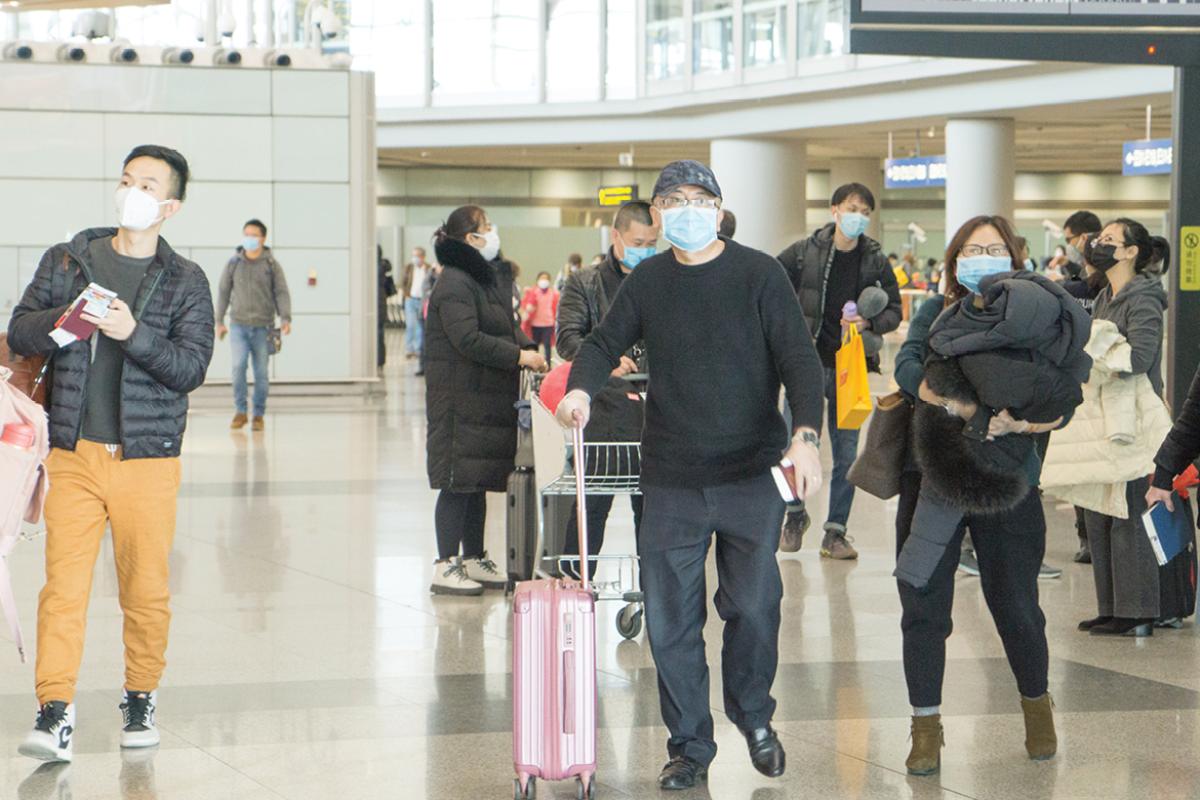 Travelers in an airport wearing face masks