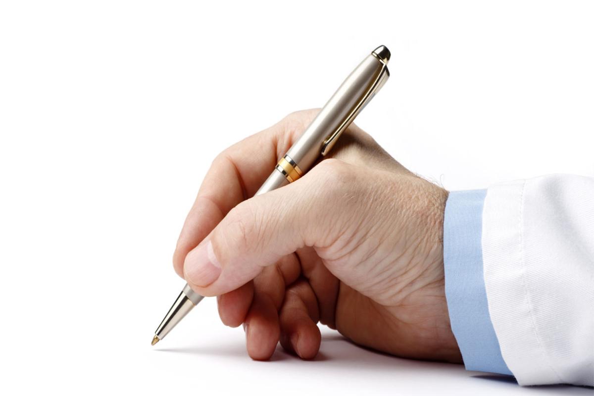 Close-up of a man signing with a pen