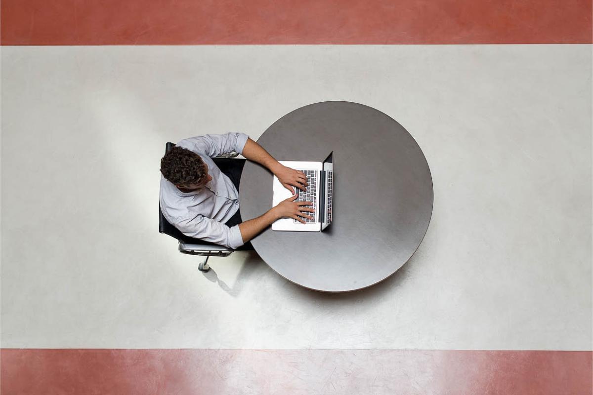 Overhead shot of man sitting in front of a laptop