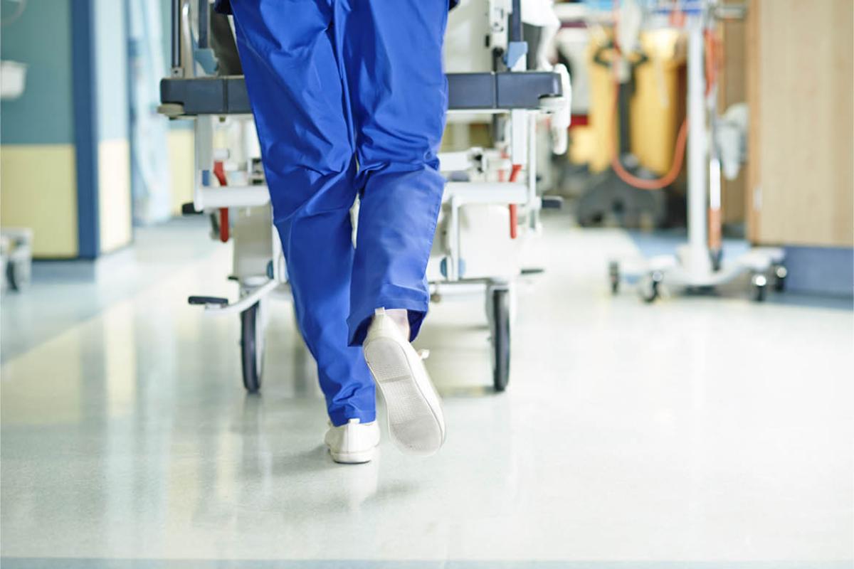 Health care worker walking down hospital hallway
