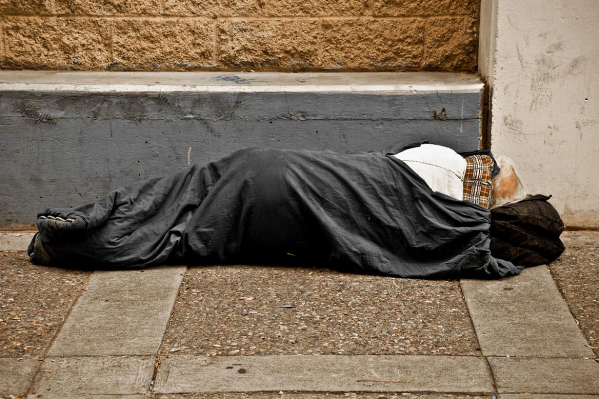 Homeless person sleeping on sidewalk