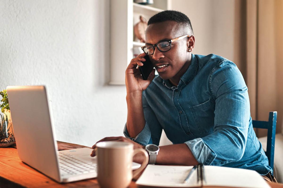 Man on phone in front of laptop