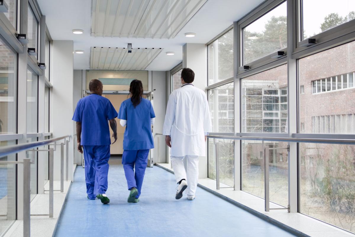 Three health care workers walking down hallway
