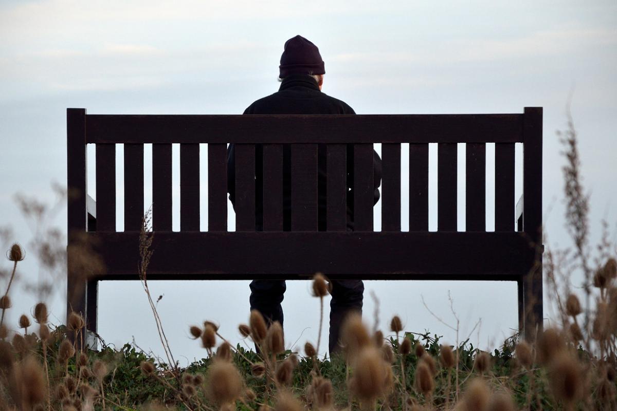 Figure sitting on park bench