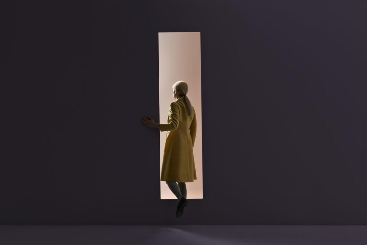 Abstract photo image of a woman walking through a door.