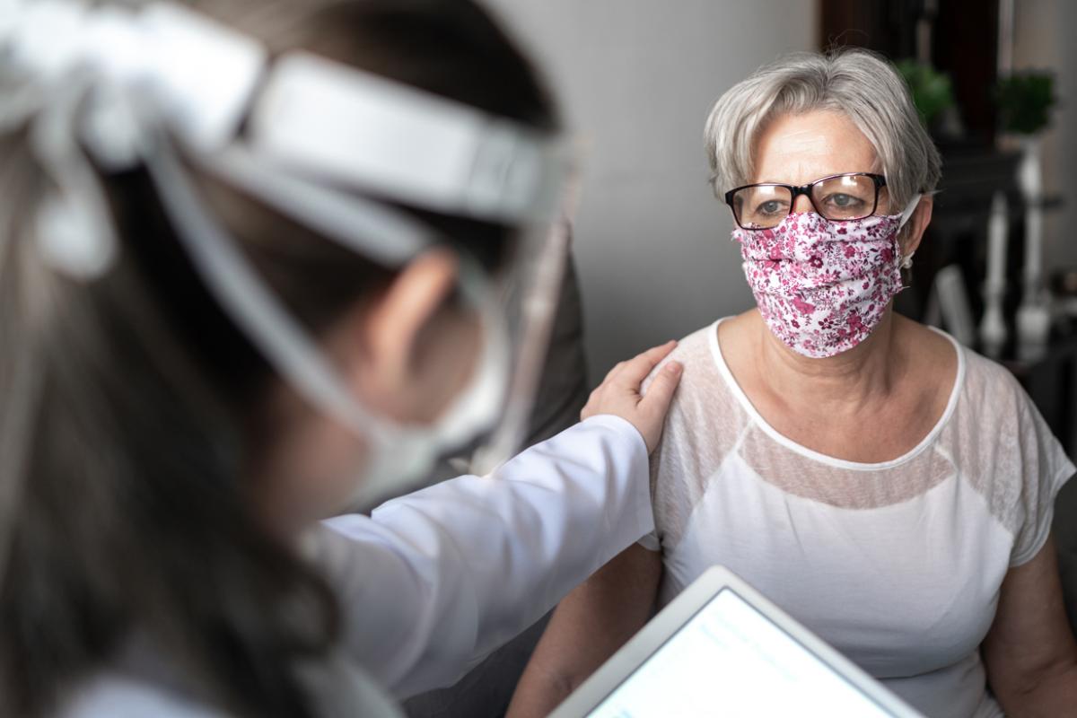 Patient in face mask with health care professional