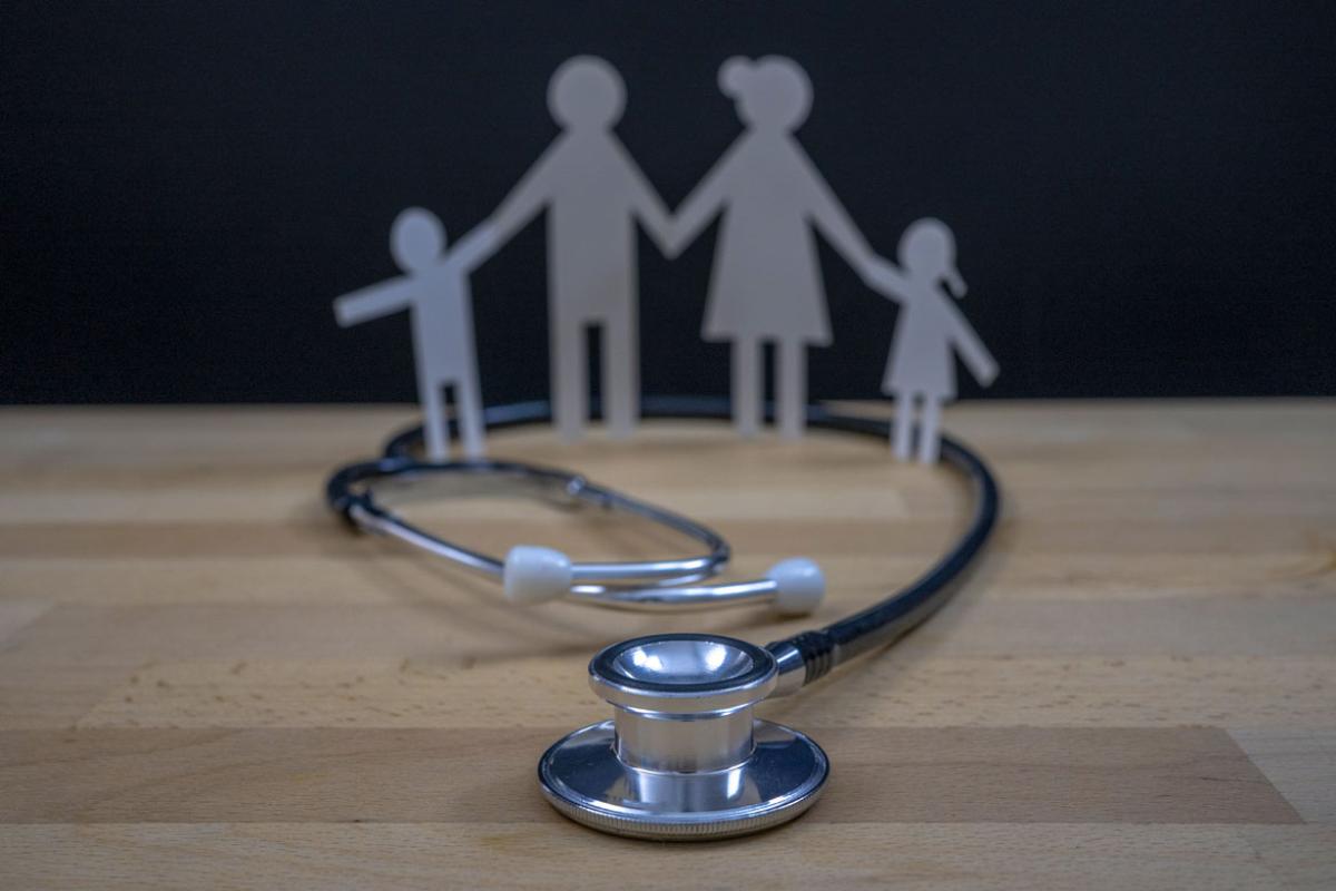 Stethoscope with a cutout image of a family in the background