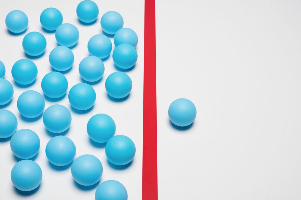 A number of turquoise balls on the left side with a red line down the center and one turquoise ball on the right side.