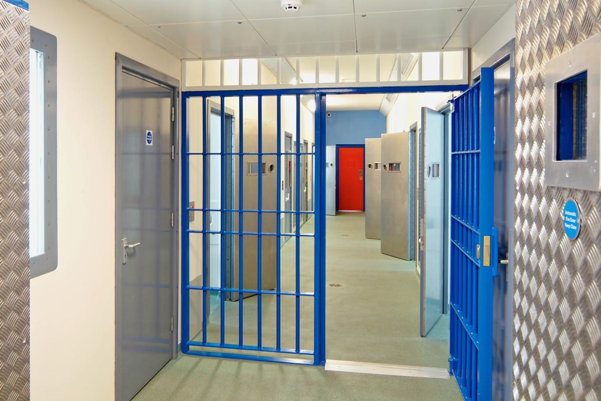 Blue prison doors and corridor leading to prison cells