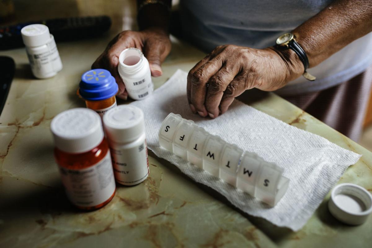 Close-up of person sorting weekly medication
