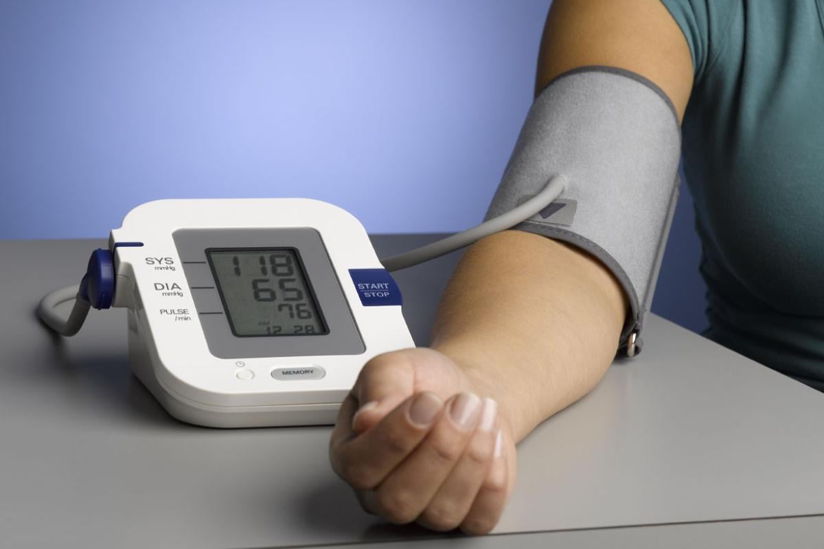 Person using an upper arm blood pressure monitor and cuff_Tight shot