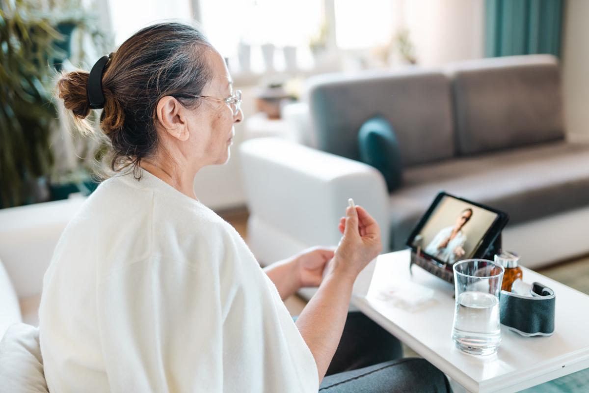 Woman with medicine in her hand talking to her doctor during a telehealth appointment.