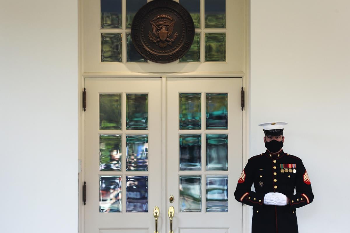 A U.S. Marine stands guard outside the West Wing at the White House