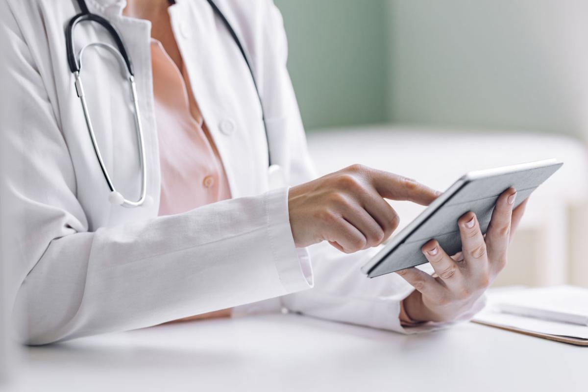 Close-up of a physician using a smart tablet.