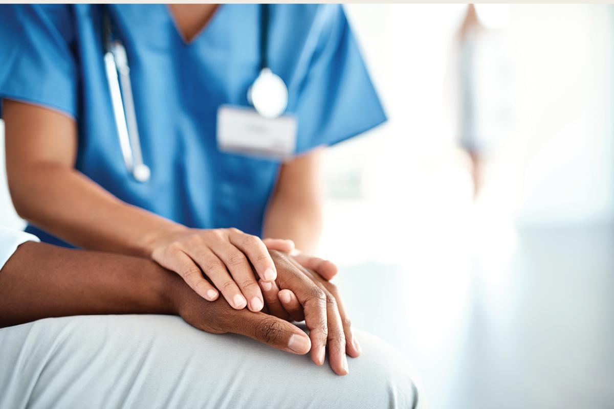 Health care worker holding a patient's hand
