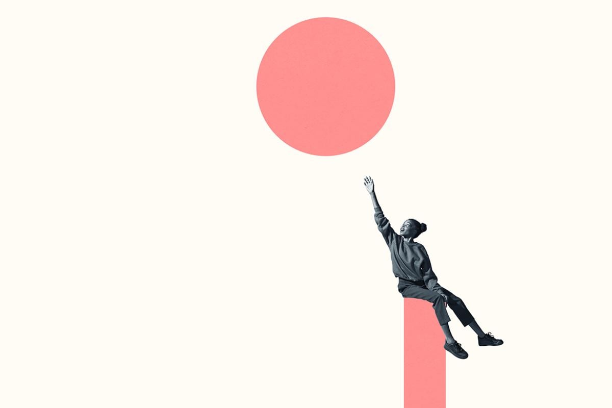 Person sitting on column while reaching for circle