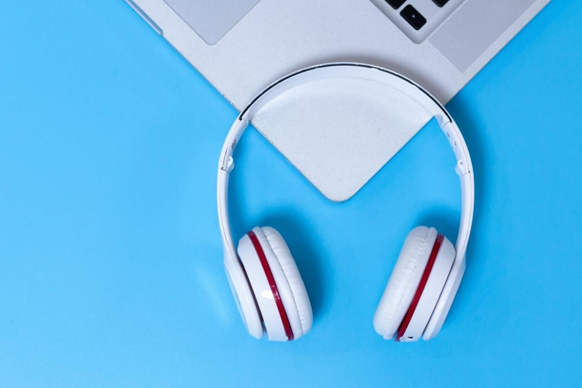 Laptop and headphones against blue background