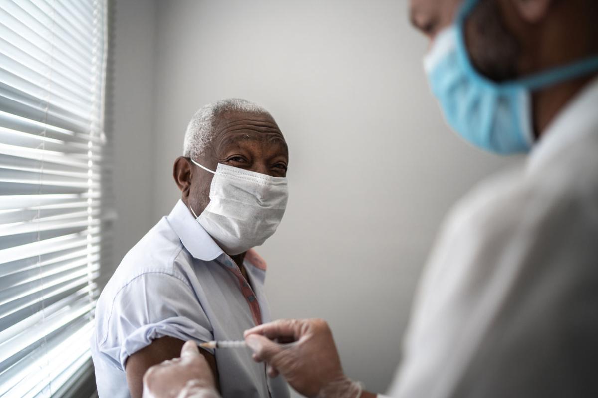 Nurse applying vaccine on patient's arm