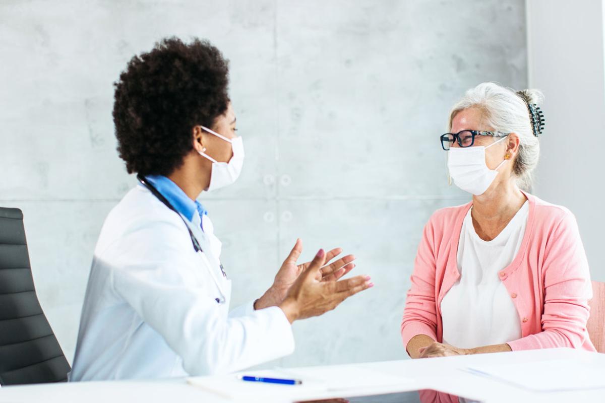 Patient and health care worker smiling behind face masks