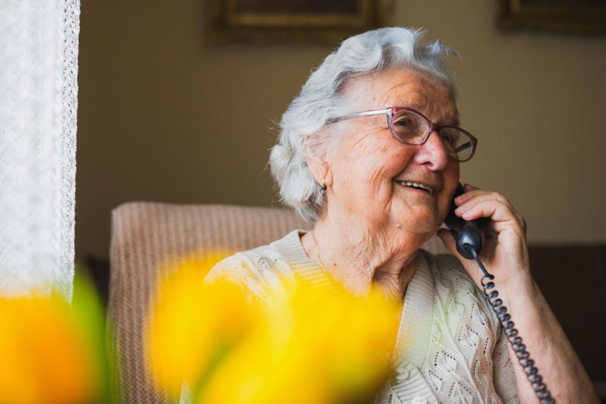 Smiling elderly person talking on the phone