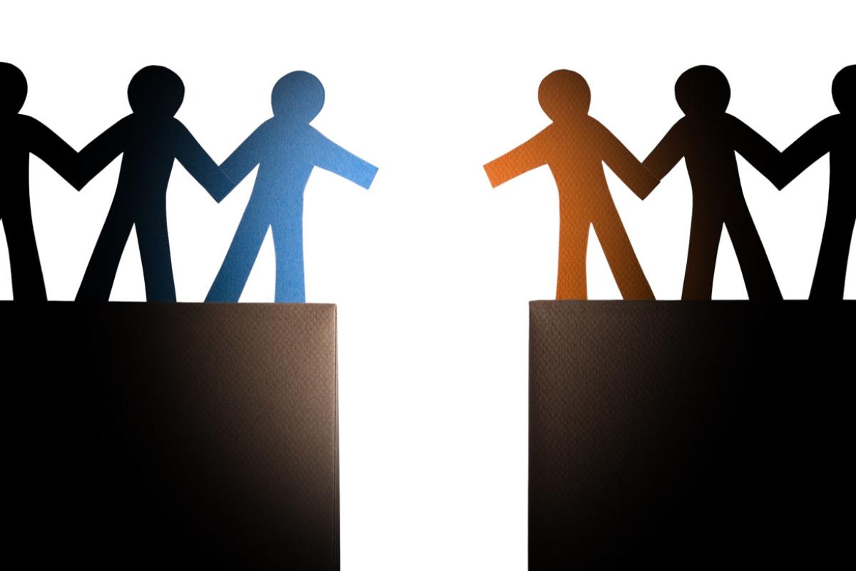 A line of paper dolls standing on a cliff reaching out to a second line of paper dolls on an opposite cliff.