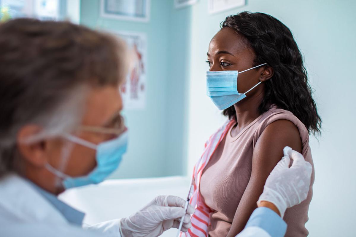 Physician prepping to administer vaccine to patient