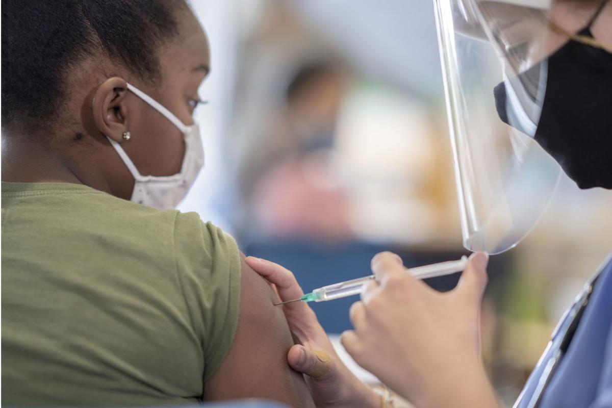 Health care worker administering vaccine to a patient