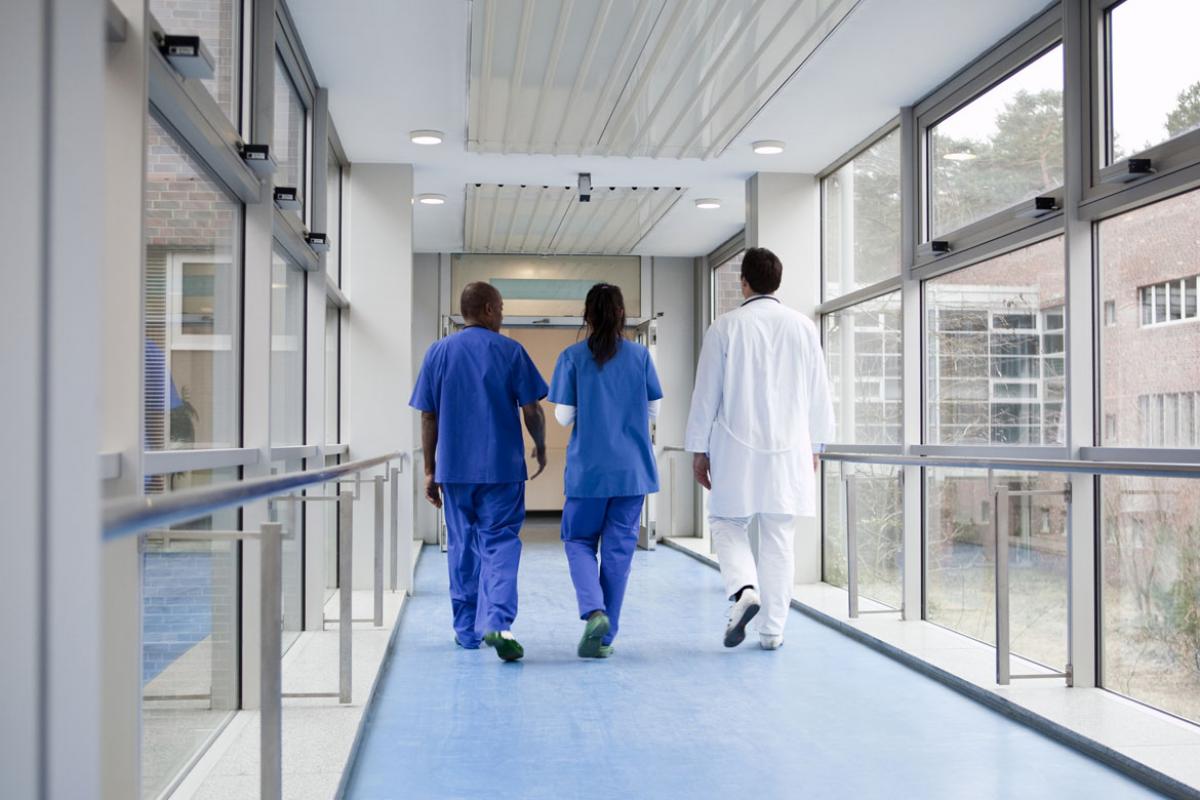 Three health care workers walking in a hallway