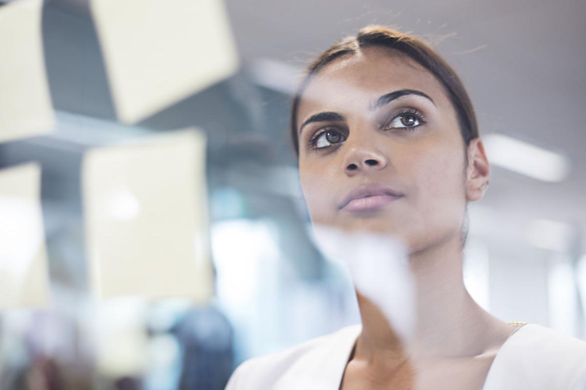 Person working at a clear dry erase board