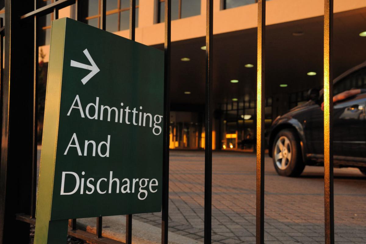 Sign outside of hospital with text indicating admitting and discharge of patients