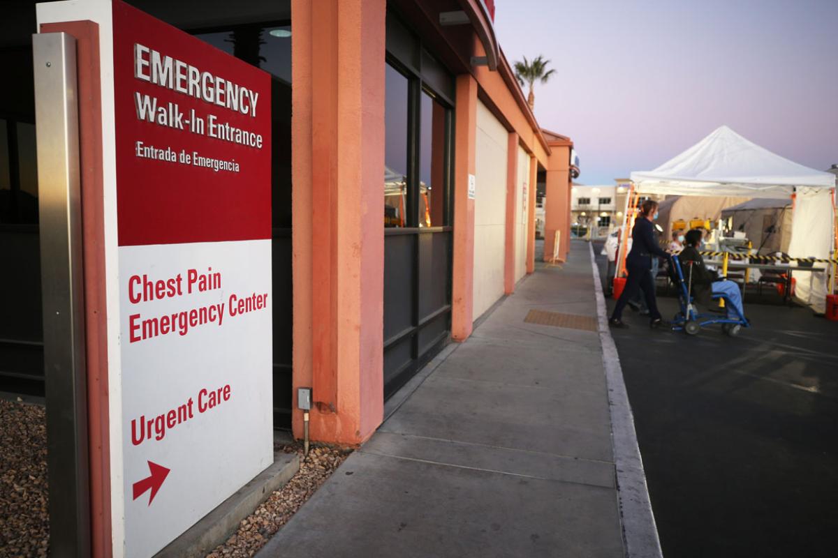 Red and white emergency entrance/urgent care sign outside of building.