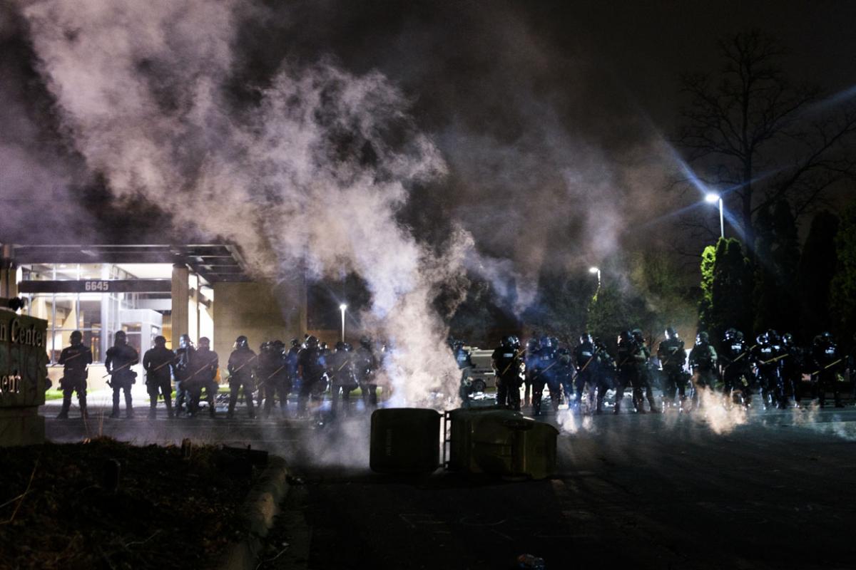 Tear gas fills the air as people confront police outside the Brooklyn Center police headquarters