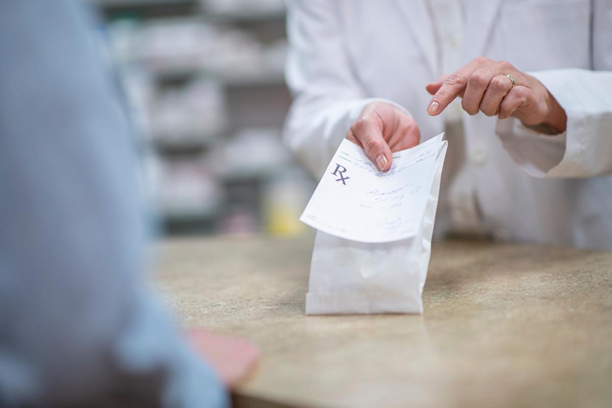 Pharmacist holding a packaged prescription 