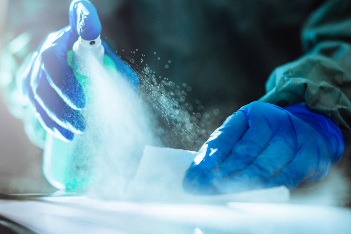 Spraying disinfectant on surface