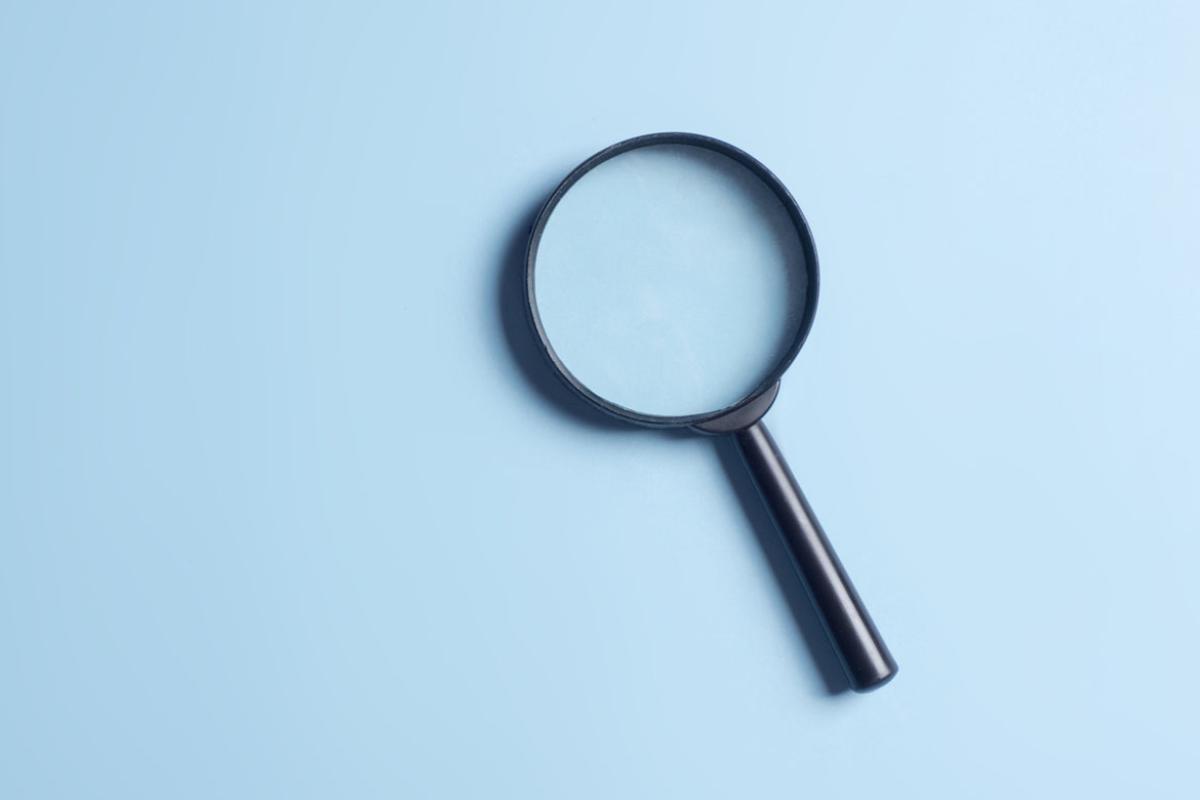 Magnifying glass on a light blue background.