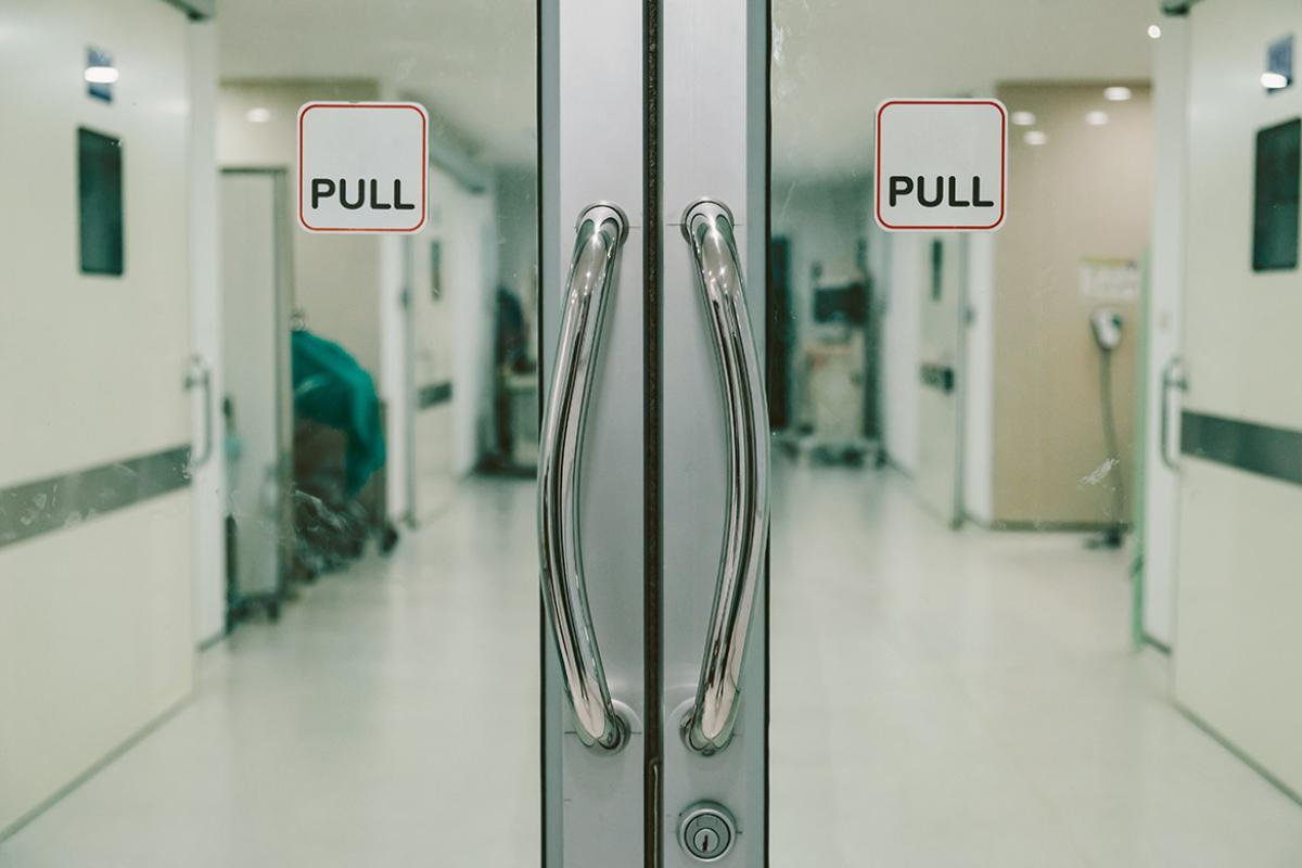 Closed glass doors with a "pull" sign leading to an operating room area