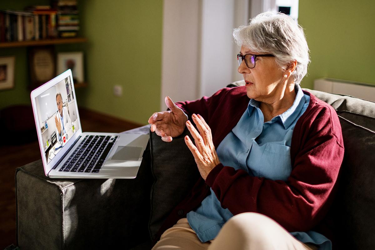 Older woman on a laptop having a virtual medical visit or telehealth appointment with a physician