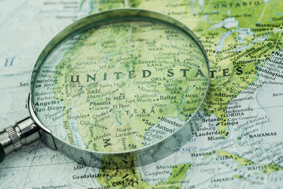 Magnifying glass on top of a map of the United States